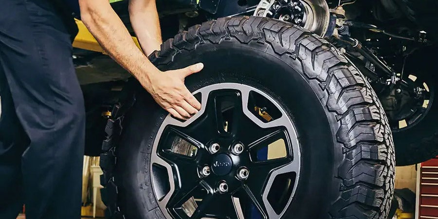 Service technician changing a Jeep tire